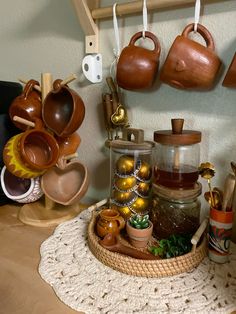 pots and pans are hanging on the wall above a tray with teapots