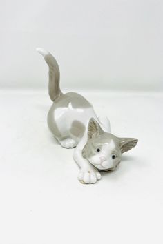 a cat figurine sitting on top of a white table