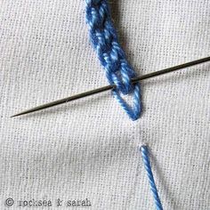 the crochet hook has been hooked up to an object that is on top of fabric