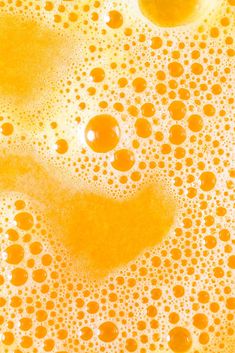 oil bubbles in water with oranges and white dots on the bottom, as seen from above