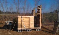 a wooden box sitting in the middle of a field