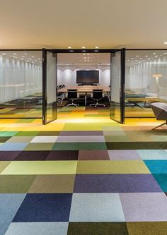 an office with multicolored carpet and glass walls