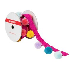 a pink and blue toy with pom poms on it