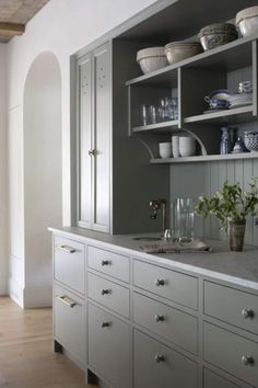 a kitchen with white cabinets and gray walls