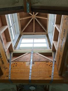 the inside of a building with wooden beams and windows in it's roof area