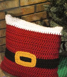 a crocheted christmas stocking sitting next to a tree