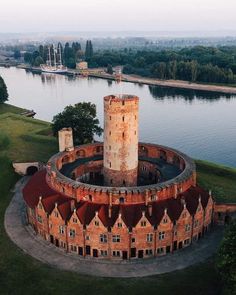 an aerial view of a castle with water in the background