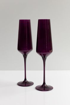 two wine glasses sitting next to each other on a table