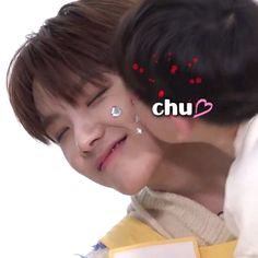 a young boy is smiling and hugging another person's head with the word chu on it