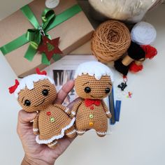 two small crocheted dolls are held up