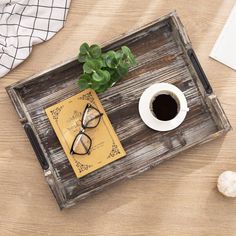 a wooden tray holding a cup of coffee and a pair of glasses on top of a table