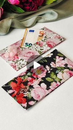 two envelopes sitting next to each other with flowers on them