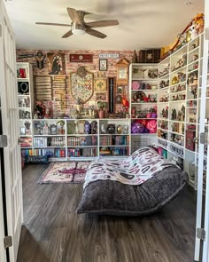 a bedroom with a bed, bookshelf and ceiling fan