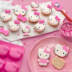 hello kitty cookies and cupcakes on a pink table