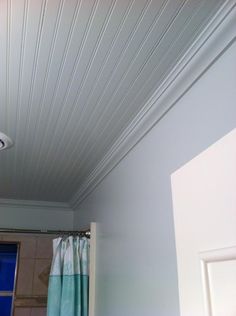 a bathroom with a blue door and shower curtain