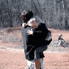 two people hugging each other in the dirt