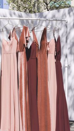 four dresses are hanging on a clothes rack