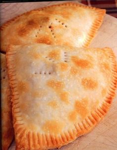 two pastries sitting on top of a wooden cutting board