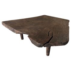 an old wooden table that has been turned into a coffee table with one leg missing