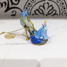 a small figurine is sitting on top of a white table with a gold chain