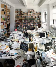 a room filled with lots of books and laptops