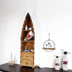 a boat shaped shelf sitting on top of a wooden table