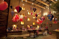 a room filled with lots of balloons hanging from the ceiling and decorations on the walls