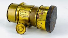 an old camera lens sitting on top of a white table next to a yellow object