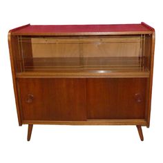 an old fashioned wooden cabinet with glass doors