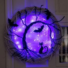 a wicker wreath decorated with purple lights and bats