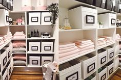 the shelves are filled with towels and other items in black and white frames on them