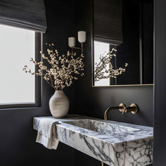 a bathroom sink with marble counter top and gold faucet