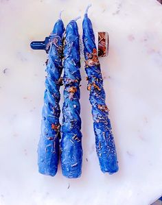 two blue umbrellas sitting on top of a white table next to an orange object