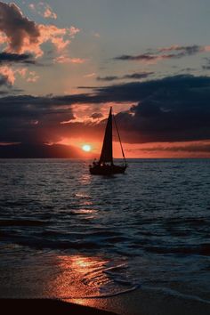 a sailboat in the ocean at sunset