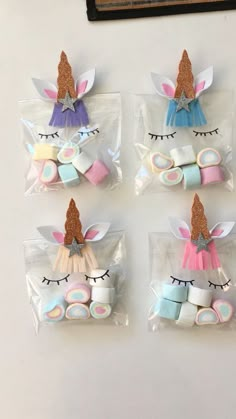 six unicorn erasers in plastic bags on top of a white table next to a wall