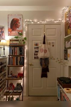 a room with a door, bookshelf and various items on the shelves in front of it