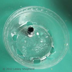 the inside of a plastic container filled with water and ice on a green table top