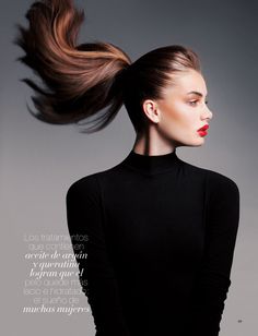 a woman with her hair in the air, wearing a black dress and red lipstick