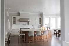 a large kitchen with an island in the middle and chairs at the counter top,