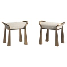 two modern stools made out of wood and fabric, one with a curved seat