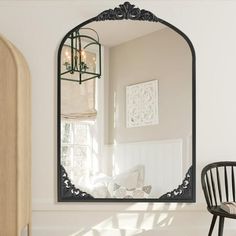 a mirror sitting on top of a white wall next to a chair and table in a room