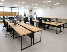 an empty office with desks and computers on the tables in front of them,