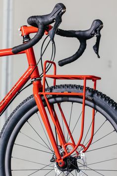 an orange bicycle parked in front of a building