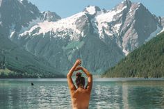 a man standing in the water with his arms above his head