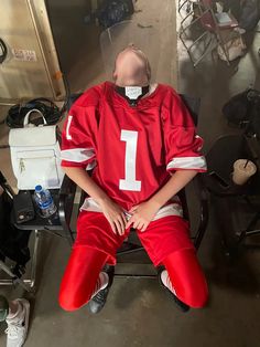 a man sitting in a chair wearing a football uniform with the number 1 on it