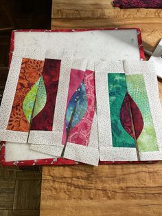 four pieces of quilted fabric laid out on a table