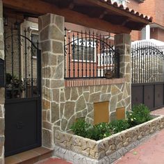 a stone building with iron gate and planters