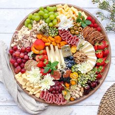 a platter filled with different types of cheese and fruit