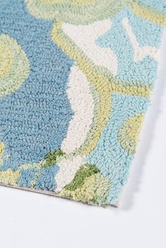 a blue and green area rug on a white surface