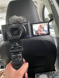 a person holding a video camera in their car